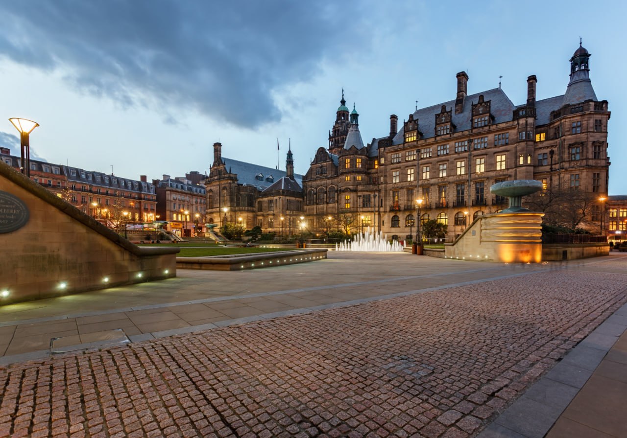 Sheffield Peace Gardens and historic city centre buildings at dusk